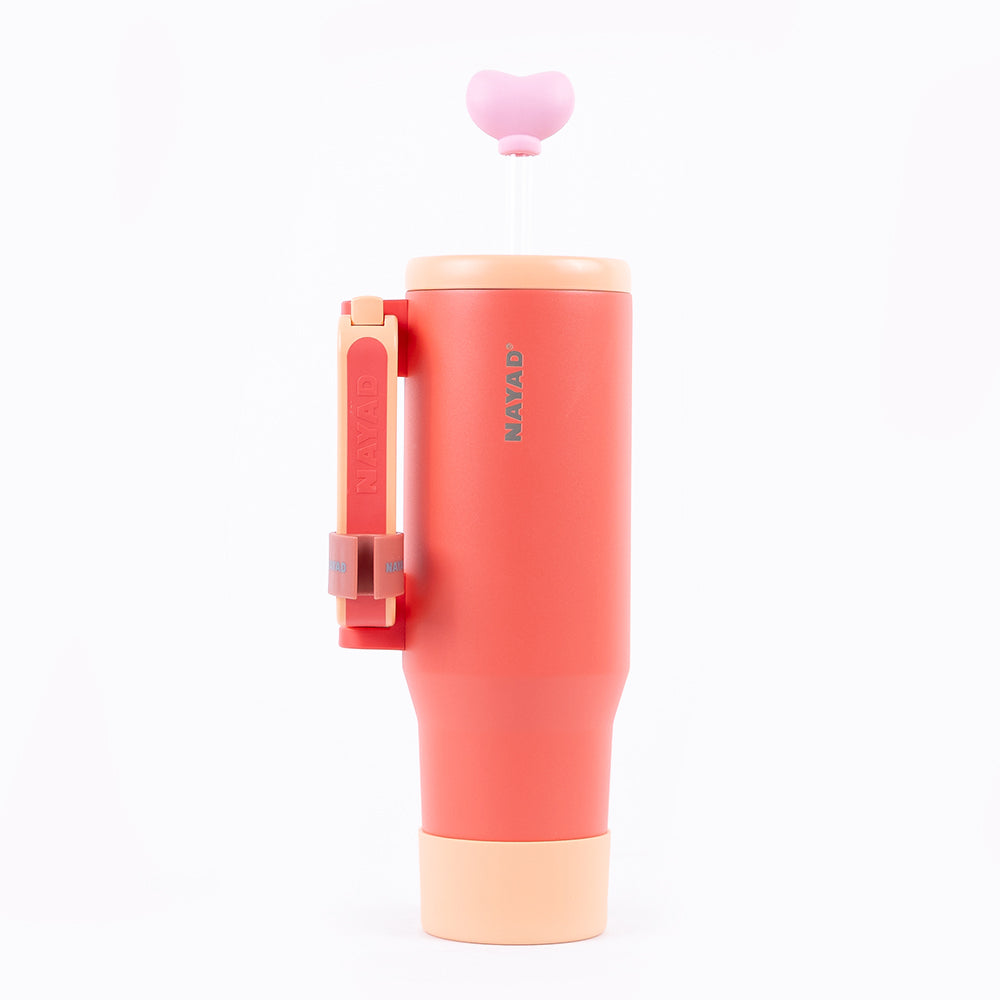 Coral-colored tumbler with a peach lid on a white background