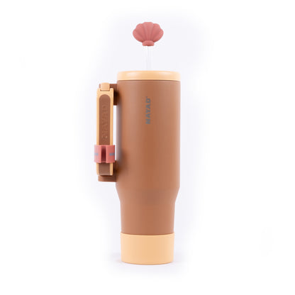 Brown tumbler with pink lid and handle on a white background
