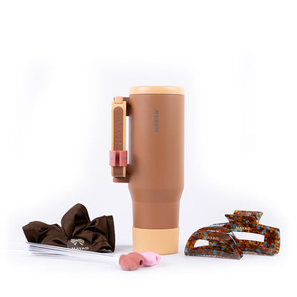 Brown tumbler with accessories on a white background