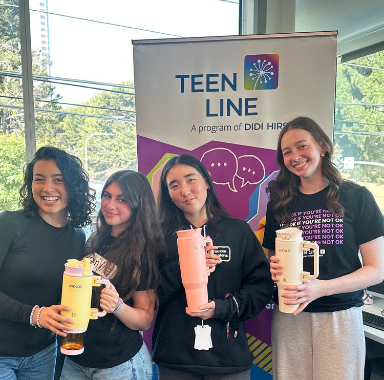 teenagers holding nayad water bottles in front of a teen line program of didi hirsch sign