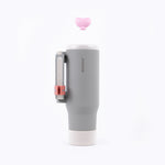 Gray tumbler with pink lid and handle on a white background