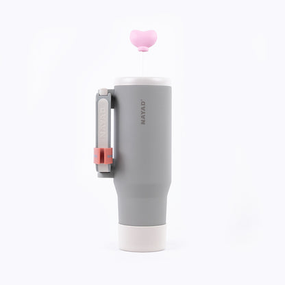 Gray tumbler with pink lid and handle on a white background