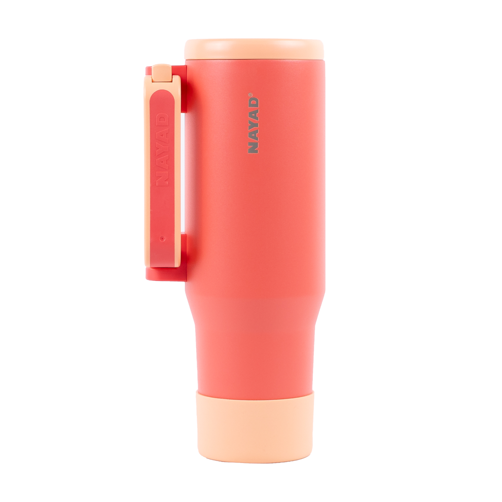 Coral-colored tumbler with a handle on a white background