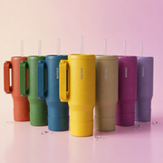 Set of colorful tumblers with handles and straws on a gradient background