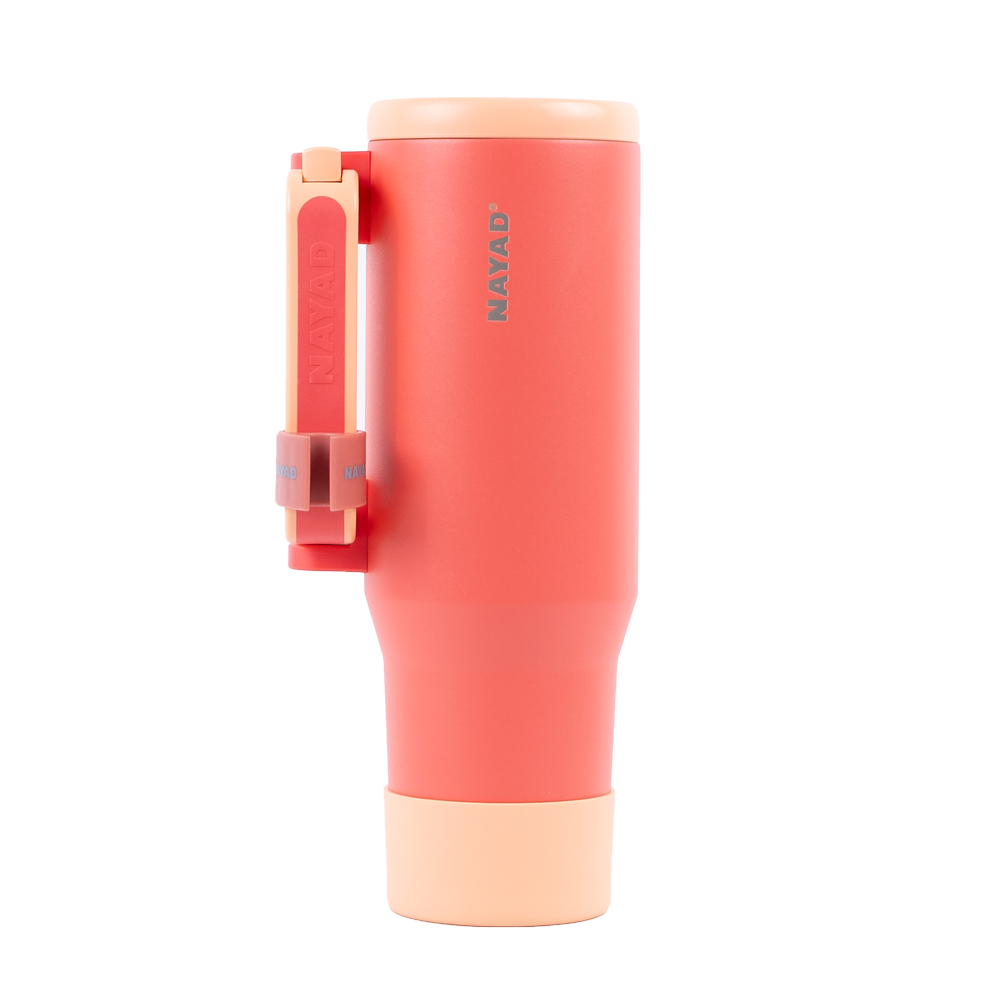 coral colored tumbler with a handle on a white background
